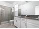 Bathroom featuring double sinks, sleek gray countertops and a glass-enclosed shower that offers a modern feel at 4290 Paragraph Dr, Kissimmee, FL 34746