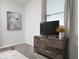 A neutral bedroom featuring a wooden dresser with a television and contemporary art on the wall at 4290 Paragraph Dr, Kissimmee, FL 34746