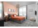 Cozy bedroom featuring a decorative orange bedspread, accent wall, and soft lighting, ideal for relaxation at 4290 Paragraph Dr, Kissimmee, FL 34746