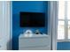 Bright bedroom featuring a television, dresser, and blue walls at 4290 Paragraph Dr, Kissimmee, FL 34746