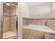 Bright bathroom with large shower and soaking tub with warm earth tone tile at 501 Pheasant Dr, Haines City, FL 33844