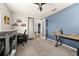 Cozy bedroom with a desk, gray carpet and a blue accent wall at 501 Pheasant Dr, Haines City, FL 33844