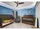 Bright Bedroom featuring 2 cribs, a recliner, and fun wall decorations at 501 Pheasant Dr, Haines City, FL 33844