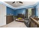 Cozy blue Bedroom with crib, dark wood furniture, recliner, and grey curtains at 501 Pheasant Dr, Haines City, FL 33844