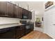 Bright kitchen with dark wood cabinets, granite countertops, and a view into the dining room at 501 Pheasant Dr, Haines City, FL 33844