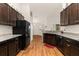 Kitchen featuring dark wood cabinets, stainless steel appliances, and wood flooring at 501 Pheasant Dr, Haines City, FL 33844