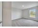 Light-filled carpeted bedroom with a large window overlooking the backyard and a single lighting fixture at 555 Viceroy Ct, Kissimmee, FL 34758