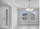 Open concept floor plan featuring a bright foyer and dining area with modern chandelier and tile flooring at 555 Viceroy Ct, Kissimmee, FL 34758