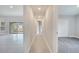 Hallway with gray tile floors and carpeted bedroom with closet doors and a bright window to the outside at 555 Viceroy Ct, Kissimmee, FL 34758