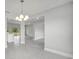 Chandelier illuminates the open living space with ceramic tile flooring and views into other rooms at 555 Viceroy Ct, Kissimmee, FL 34758