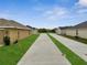 Wide street with well-manicured lawns showcases a modern, planned community at 555 Viceroy Ct, Kissimmee, FL 34758