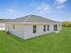 Back exterior of house showing windows, sliding glass doors, and well-maintained lawn at 557 Viceroy Ct, Kissimmee, FL 34758