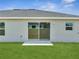 Backyard exterior showing a well-maintained lawn and sliding glass doors at 557 Viceroy Ct, Kissimmee, FL 34758