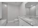 Bathroom with gray tile, granite countertops, and a large mirror for added convenience at 557 Viceroy Ct, Kissimmee, FL 34758