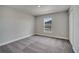 Cozy bedroom with neutral walls, carpet flooring, and a well-lit window at 557 Viceroy Ct, Kissimmee, FL 34758