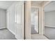 Bright hallway with white trim, doors, neutral walls, and soft carpet leads to multiple rooms at 557 Viceroy Ct, Kissimmee, FL 34758