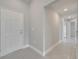 A long hallway with gray tile floors leading to the front door and other rooms at 557 Viceroy Ct, Kissimmee, FL 34758