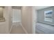 Hallway leads to a bedroom with carpet floors and a window offering plenty of natural light at 557 Viceroy Ct, Kissimmee, FL 34758