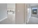 Hallway view of kitchen with stainless steel appliances and bedroom with carpeted floors and a bright window at 557 Viceroy Ct, Kissimmee, FL 34758