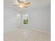 Bright bedroom with tile floors, ceiling fan, and window overlooking greenery at 6548 Swissco Dr # 61, Orlando, FL 32822