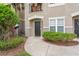 Close-up of a welcoming townhouse entrance with lush green landscaping and a 'hello' doormat at 6548 Swissco Dr # 61, Orlando, FL 32822