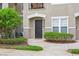 Townhouse entrance featuring a dark door, manicured shrubs, and a window for natural light at 6548 Swissco Dr # 61, Orlando, FL 32822