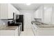 Modern kitchen with granite counters, white cabinets, stainless steel appliances, and tile flooring at 6548 Swissco Dr # 61, Orlando, FL 32822