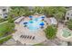 Aerial view showcases a community pool with umbrellas, lounge chairs, and verdant landscaping at 6548 Swissco Dr # 61, Orlando, FL 32822