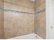Close-up of tiled shower stall with decorative accent tiles and updated fixtures at 6548 Swissco Dr # 61, Orlando, FL 32822