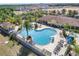 Aerial view of the community pool, clubhouse, lounge chairs, and lush palm trees at 7521 Pellham Way, Kissimmee, FL 34747