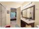 Bathroom with a vanity, mirror, and shower, with a view into the bedroom at 7521 Pellham Way, Kissimmee, FL 34747