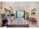 Bright bedroom with a large bed, ceiling fan, dresser, TV, and access to the lanai at 7521 Pellham Way, Kissimmee, FL 34747