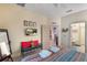 Bright bedroom with a television, bench, and a view into an adjacent room and bathroom at 7521 Pellham Way, Kissimmee, FL 34747