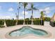 Inviting hot tub with clear water, surrounded by lush hedges and palm trees at 7521 Pellham Way, Kissimmee, FL 34747