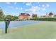Well-maintained tennis court surrounded by lush greenery and residential buildings at 7521 Pellham Way, Kissimmee, FL 34747