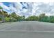 Well-maintained community tennis court surrounded by lush greenery and a secure fence at 7521 Pellham Way, Kissimmee, FL 34747