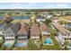 Aerial view of houses with swimming pools, patios, and landscaping near a picturesque lake at 781 Golden Bear Dr, Kissimmee, FL 34747