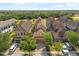 Aerial view of multiple homes with manicured lawns, mature trees, and a glimpse of a scenic golf course in the distance at 781 Golden Bear Dr, Kissimmee, FL 34747