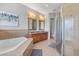 Spacious bathroom with a tub, glass shower, and dual sink vanity with granite countertops at 781 Golden Bear Dr, Kissimmee, FL 34747