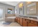 Modern bathroom features large tub and granite countertop with dual sinks and a view at 781 Golden Bear Dr, Kissimmee, FL 34747