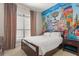 Bedroom featuring a colorful mural, a bed and bedside table beneath a large window with curtains at 781 Golden Bear Dr, Kissimmee, FL 34747