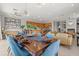 Open-concept dining room features a long wooden table with blue upholstered chairs and modern light fixture at 781 Golden Bear Dr, Kissimmee, FL 34747