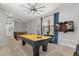 Open game room features pool table, ceiling fan, and tv; ideal for entertaining guests at 781 Golden Bear Dr, Kissimmee, FL 34747