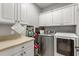 Laundry room featuring white cabinets, a countertop, and modern appliances at 781 Golden Bear Dr, Kissimmee, FL 34747