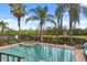 Backyard pool and spa with a brick border, surrounded by lush landscaping and a black fence at 781 Golden Bear Dr, Kissimmee, FL 34747