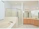 Bright bathroom features a glass shower, a soaking tub, and double sinks with a large mirror at 847 Orista Dr, Davenport, FL 33897