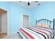 Comfortable bedroom features blue walls, a ceiling fan, and a wrought iron bed frame at 847 Orista Dr, Davenport, FL 33897