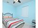 Comfortable bedroom features blue walls, a ceiling fan, and a wrought iron bed frame at 847 Orista Dr, Davenport, FL 33897