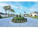 Landscaped community entrance with manicured foliage, seasonal flowers and palm trees at 847 Orista Dr, Davenport, FL 33897