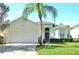 Inviting single-story home with a well-manicured lawn and a majestic palm tree in the front yard at 847 Orista Dr, Davenport, FL 33897